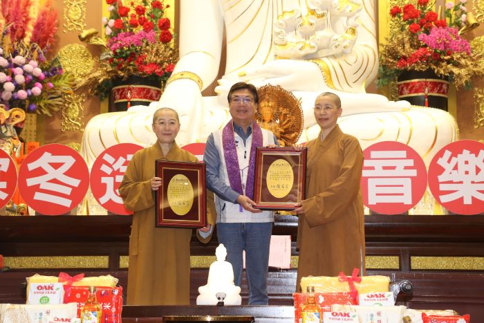 宗教力量撫慰人心 金光明寺音樂饗宴寒冬送暖12年 43 《圖說》副市長劉和然代表侯友宜市長頒贈感謝牌給覺培師父(左)和有果師父(右)。〈社會局提供〉