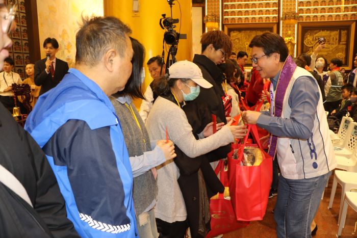 宗教力量撫慰人心 金光明寺音樂饗宴寒冬送暖12年 44 《圖說》劉和然副市長致贈福袋給參加的福田戶。〈社會局提供〉
