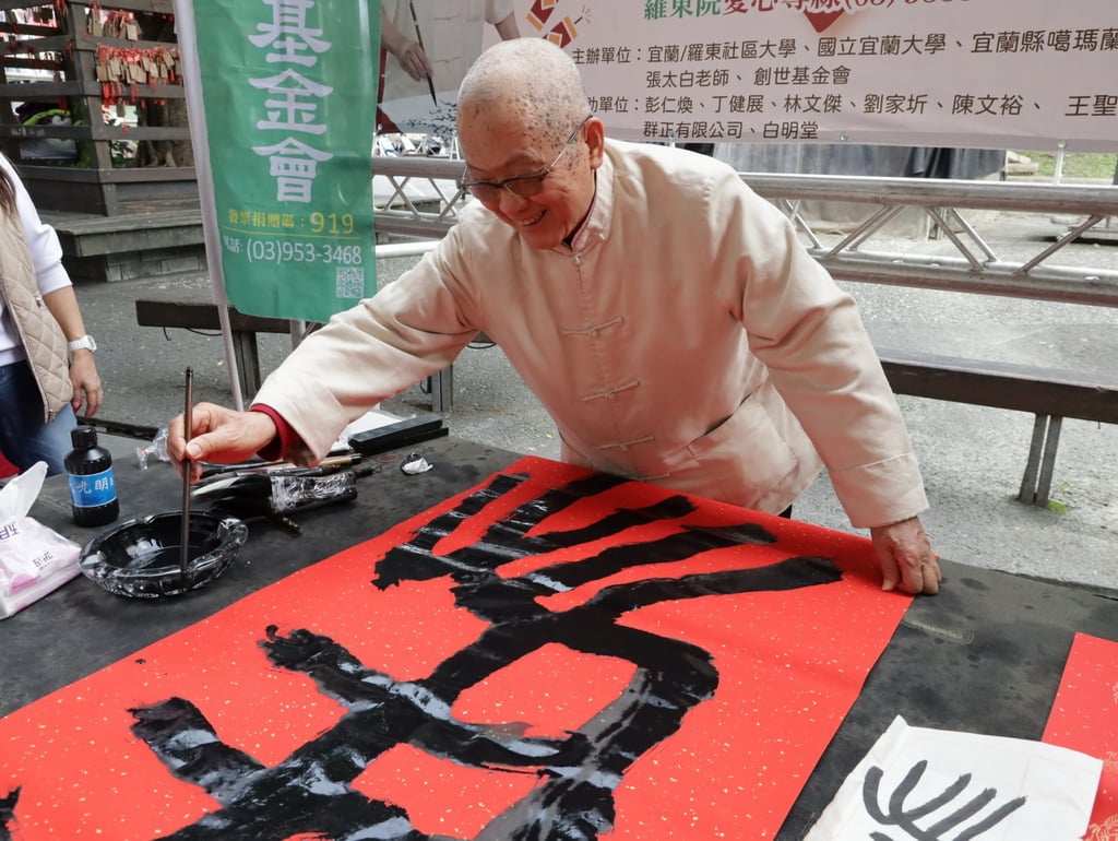 ▲書法名家張太白現場揮毫寫春聯,以墨寶義賣支持創世基金會植物人常年照護服務。