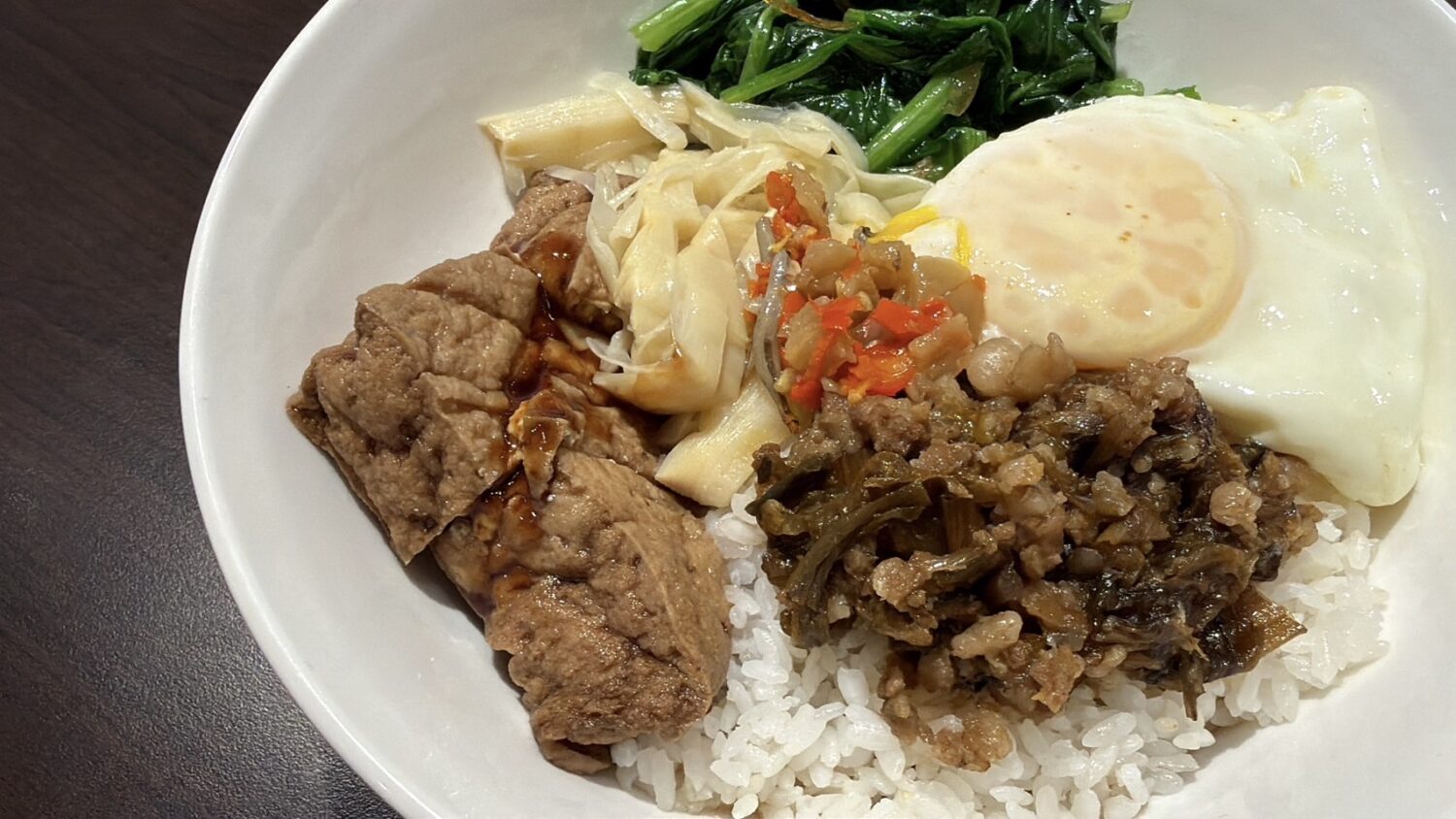 「福氣東來飯」以梅乾菜搭配絞肉,鋪上金黃太陽蛋,融合傳統客家古早味與現代餐食美學,成為店內新的人氣選擇。(圖/記者林照東攝)