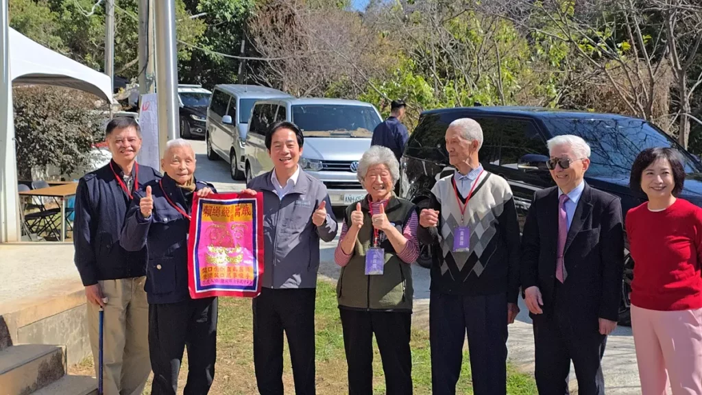 賴清德總統於春節前夕參與弘道老人福利基金會「寒冬助老服務」,前往台中大坑山區,探訪因家庭變故而獨居的 88 歲邱阿公(右三)。百歲鍾波球爺爺(左二)特別為總統準備魔術表演並親手贈送禮物。(圖/陳惠玲攝影)