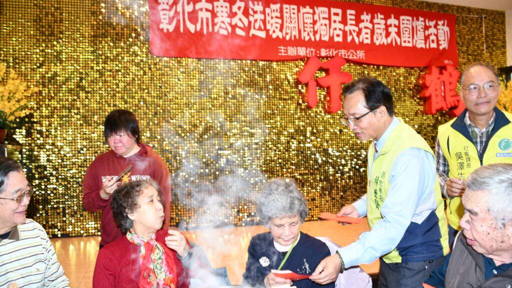 ▲獨居長者圍爐餐會林世賢市長逐一發紅包。(圖/記者林明佑翻攝)