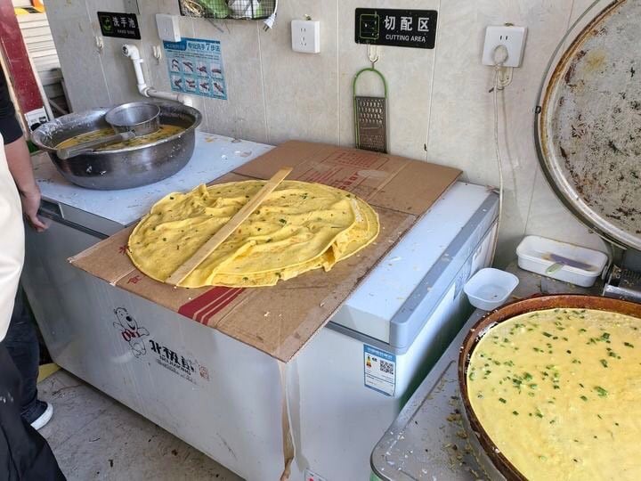 ▲圖為某外送門市後廚的場景,煎餅直接放置在紙殼上。