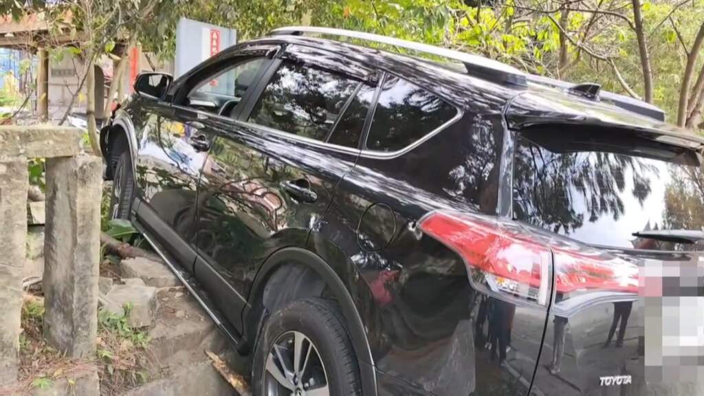 ▲彰化縣社頭鄉百年古剎清水岩寺今日下午驚傳意外，一輛休旅車行經廟前廣場時，疑似突然失控暴衝，先撞毀廟方百年石欄杆，隨後衝上上方綠地卡住動彈不得。（圖／記者林明佑翻攝）