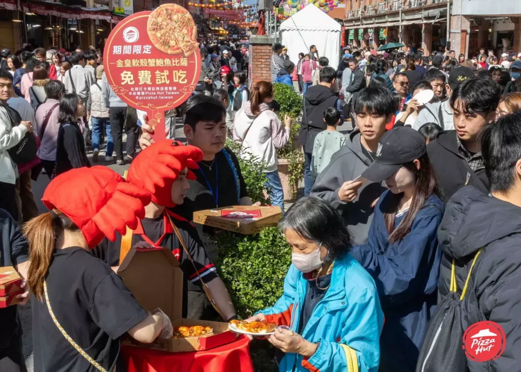 必勝客現場發送200份「金皇軟殼蟹鮑魚比薩」免費試吃,濃郁香氣吸引民眾排隊領取,人潮絡繹不絕。