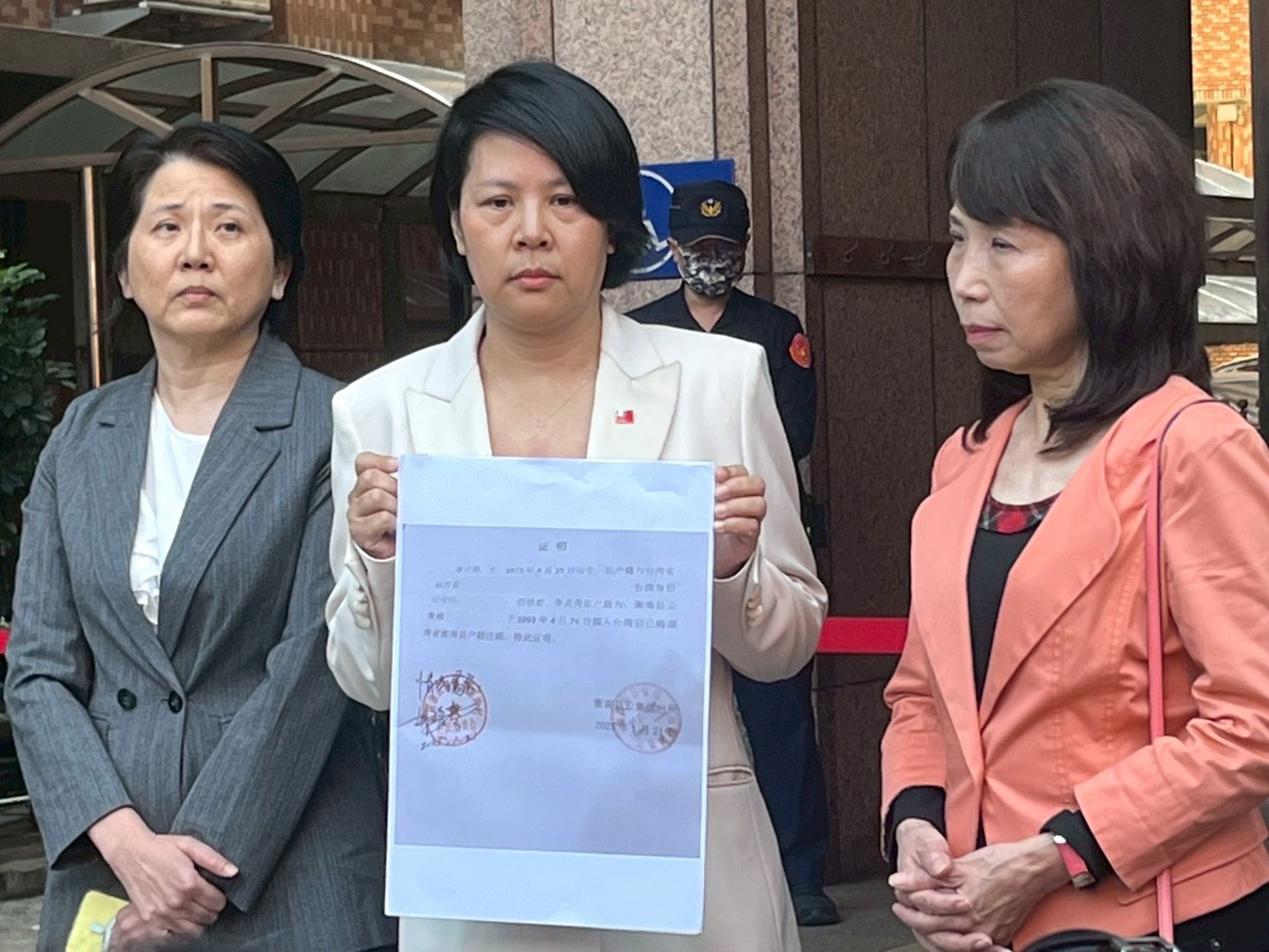 立法委員李貞秀於行政院中央聯合辦公大樓前召開記者會,手持相關證明文件,說明國籍與戶籍程序始末,強調身分合法。(圖/記者林照東攝)