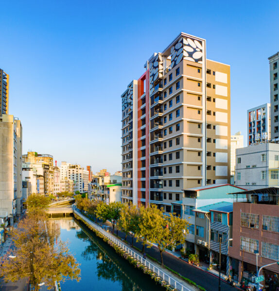「皇逸居」外觀實景,坐擁幸福川首排水岸景觀,結合現代建築設計與城市天際線,展現高雄車站核心生活圈的嶄新風貌。圖/業者提供