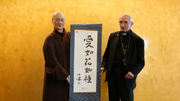 世界宗教博物館25周年 迎教廷代表展開跨信仰交流 44 《圖說》世界宗教博物館發展基金會執行長顯月法師(左)致贈創辦人心道法師所書的「愛如花如種」卷軸,給天主教義大利樞機主教托瑪士。〈宗博館提供〉