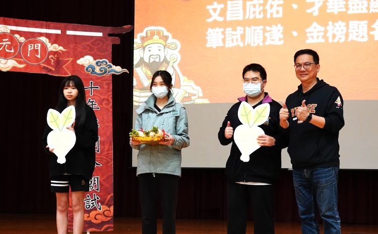統測進入關鍵倒數 各校創意祈福穩定考生心情 32 《圖說》鶯歌工商校長帶領學生,以蘿蔔、包子、粽子寓意「好彩頭、包中、包粽」展現校園陪伴。〈教育局提供〉