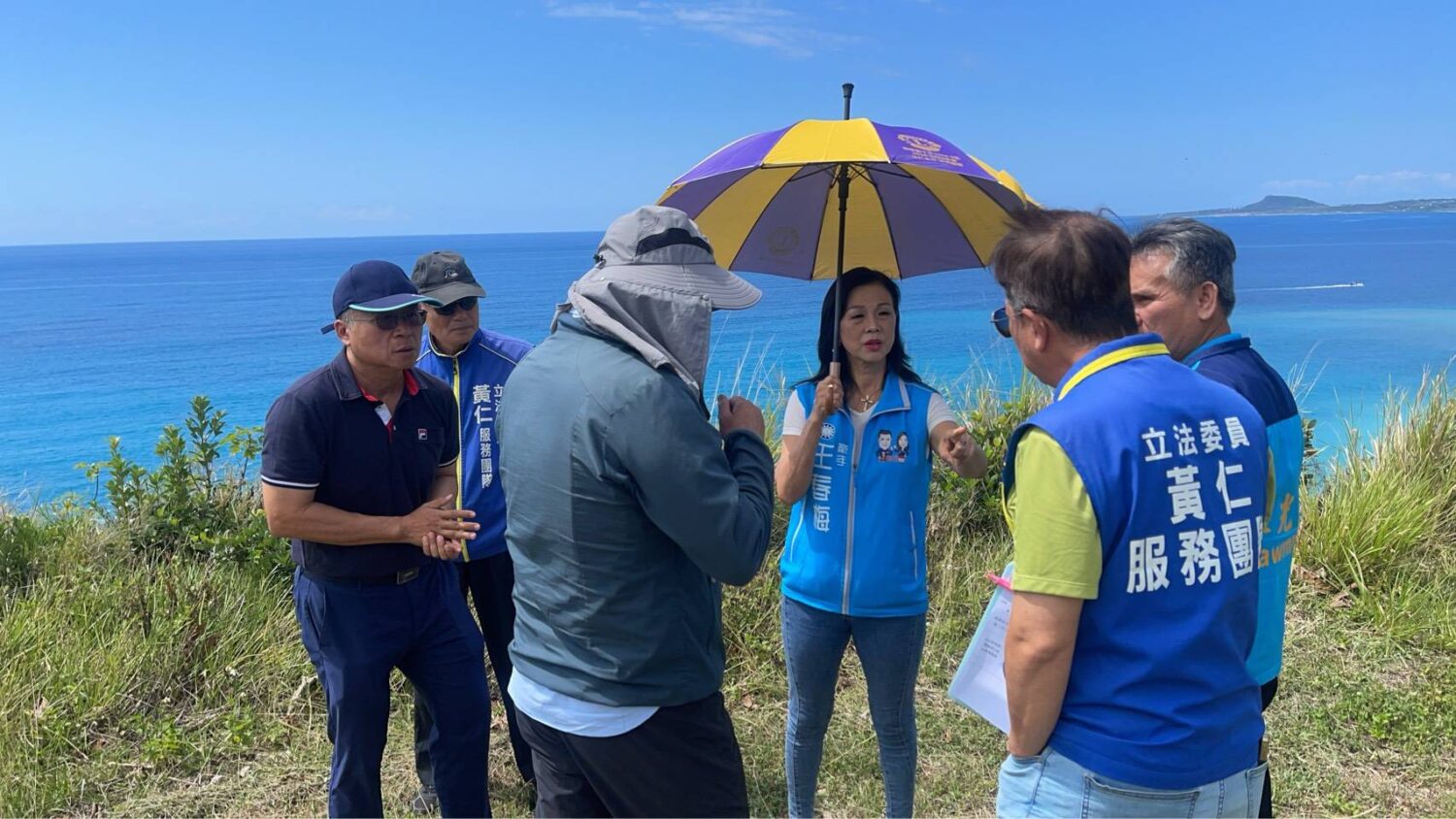 頂著初夏大太陽,王春梅在會勘現場與工作人員研商如何落實海岸保護及居民生活安全相關規劃。(記者 包克明翻攝)