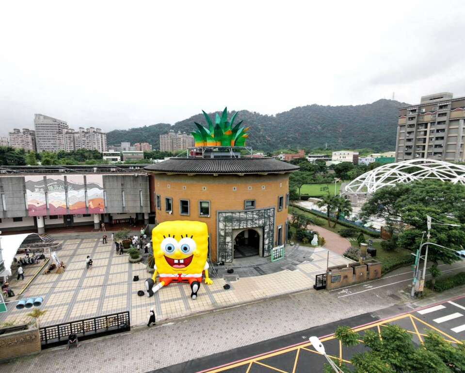 ▲新北市客家文化園區的「客家圓樓」變身為超吸睛的巨型「鳳梨屋」,還有超萌的海綿寶寶大氣偶坐鎮迎接,展現都會客家與國際 IP 跨界結合的創新趣味。