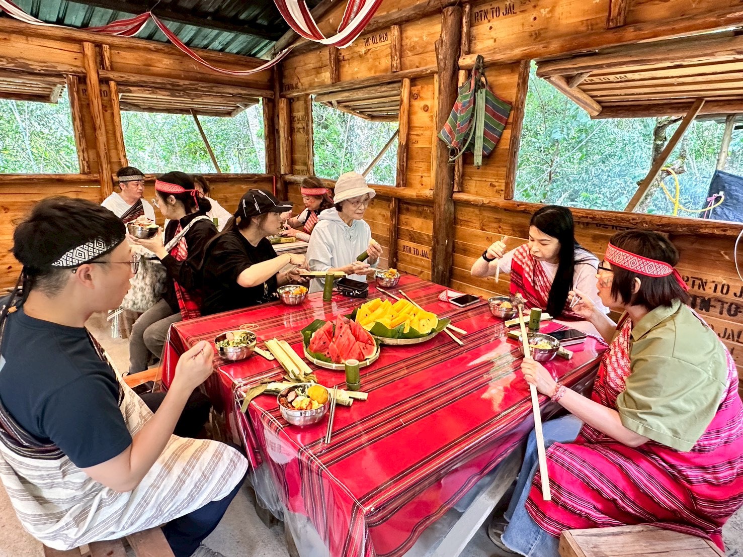 參加「漫遊烏來小旅行」的民眾穿上泰雅族傳統服飾，在原民風格木屋內享用部落特色料理，透過美食與文化交流，深入感受烏來泰雅族生活魅力。(圖/新北市烏來區公所提供)