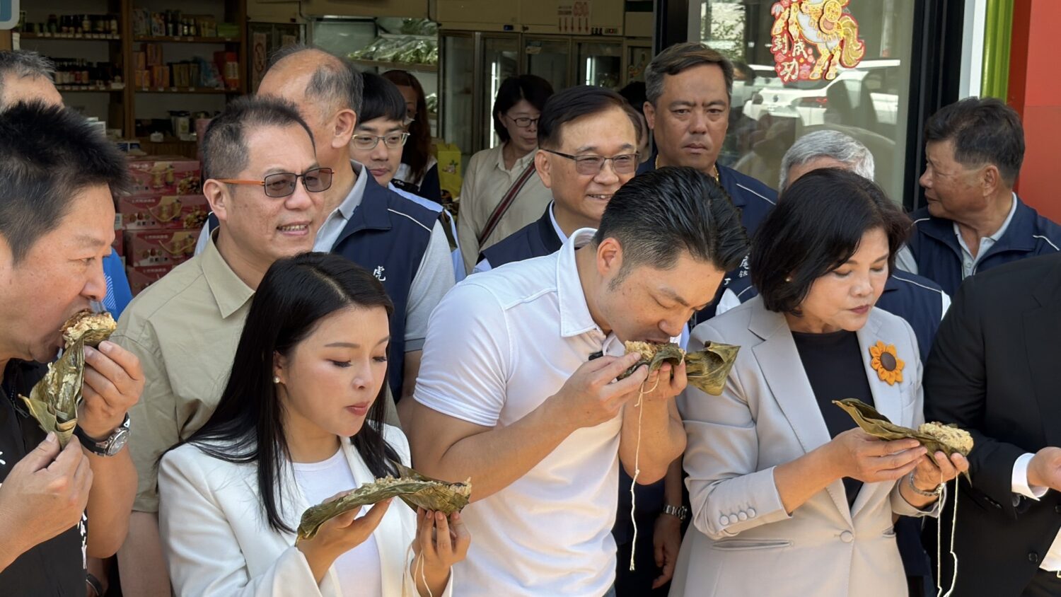 蔣萬安(中)、張麗善(右)現場品嚐虎尾產銷履歷花生粽,大讚花生香氣濃郁、口感紮實。(圖/記者 張泓笙翻攝)
