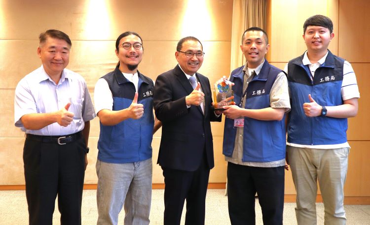 新北建照AI輔助審查奪智慧城市創新獎 侯:打造宜居智慧城 23 《圖說》新北市「建築執照AI輔助審查系統」獲得2026智慧城市創新應用獎,工務局長馮兆麟(左一)率領得獎同仁獻獎予侯友宜市長(左三),共享榮耀。〈工務局提供〉