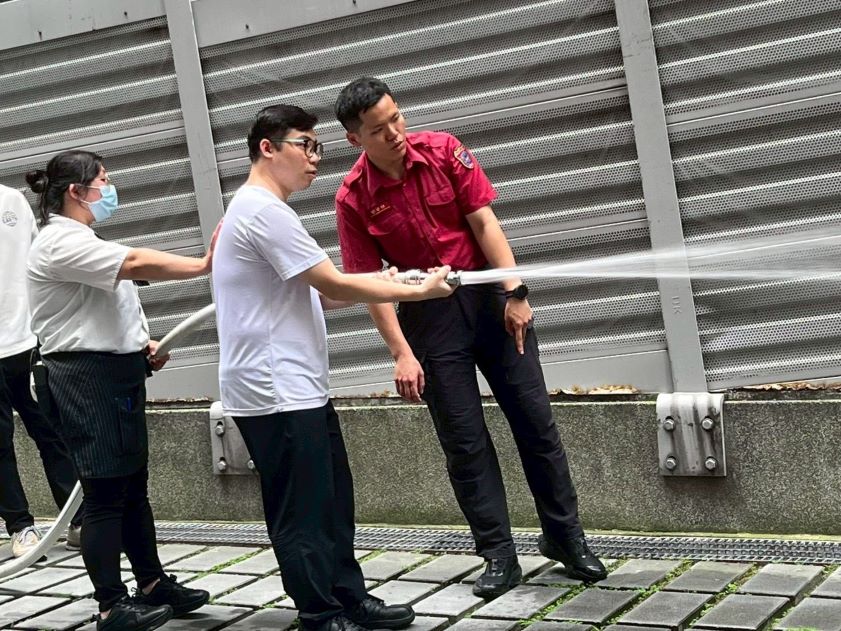 迎戰端午連假人流 新北消聯手百貨業守護民眾安全 29 《圖說》參訓人員親身體驗滅火器噴射時的後座力。〈第一大隊提供〉