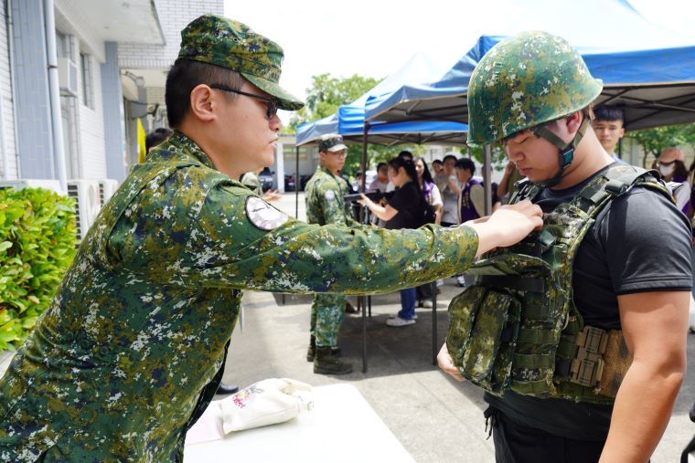 開拓多元職涯 新北攜手國軍助弱勢青年翻轉人生 59 《圖說》參訪空軍憲兵中隊,青年體驗穿放防彈衣。〈社會局提供〉二