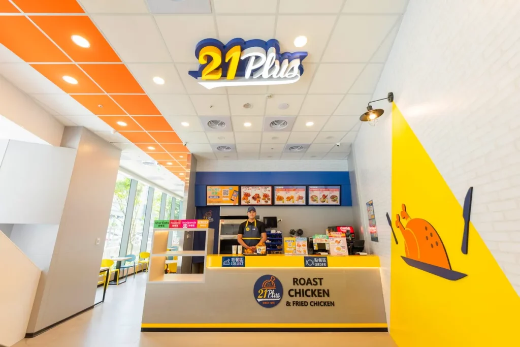 21PLUS愿秀門市-櫃台正面門市全景照,天花板logo造型燈箱,客席落地窗外楓樹營造悠閒氛圍