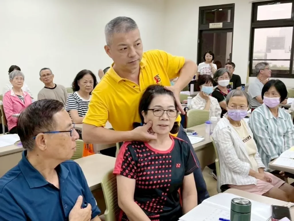 「經絡推拿」課程現場示範推拿技巧，學員近距離學習日常保健方法。（圖/中山醫大提供）