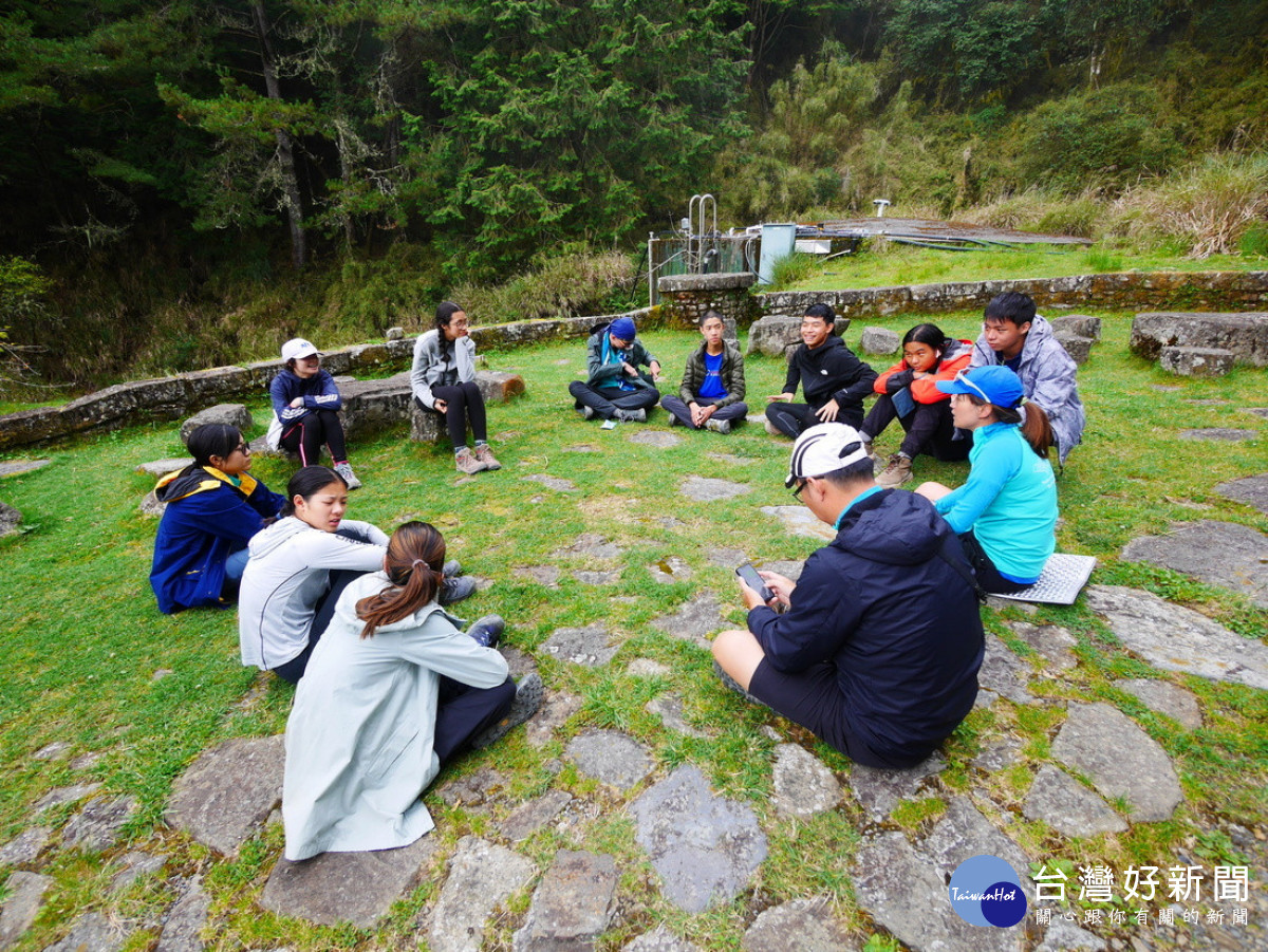 嚮導與學員在排雲登山服務中心前席地而坐進行營隊課程。(圖/玉管處提供)
