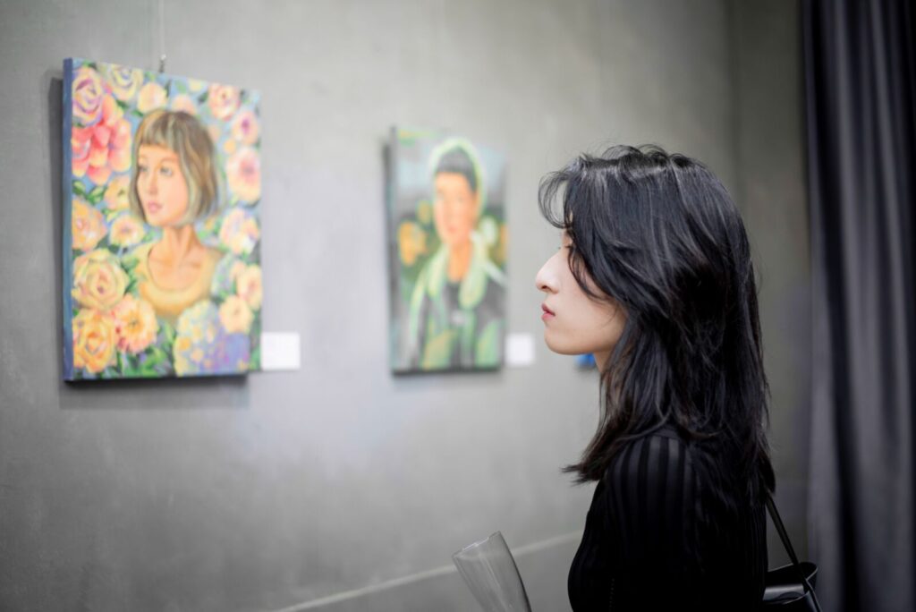 觀展民眾專注凝視簡名辰的繽紛創作。簡名辰細膩且充滿生命韌性的作品筆觸，讓許多觀展者產生共鳴。圖/說說畫Art Studio提供
