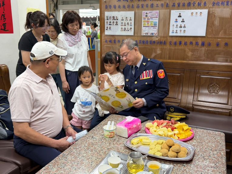 雨中追憶英雄身影 土城警警察節揭牌「正義之光」追念英勇所長 49 《圖說》劉所長年幼的兩位女兒,獻上親手繪製的圖畫給廖訓誠副署長。稚嫩筆觸描繪的不只是童真的色彩,更蘊含著孩子對父親深深的思念與驕傲,讓在場許多人紅了眼眶。〈土城分局提供〉