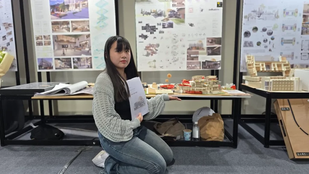 學生林子涵說明作品「垂直動線的穿透性」，保留既有通學動線，並將其轉化為貫穿基地的公共通道；室內則以坡道串聯空間，並圍繞一棵「生長之樹」構築垂直軸線，形塑如劇場般開放且具自然意象的空間體驗。（圖/陳惠玲攝影）