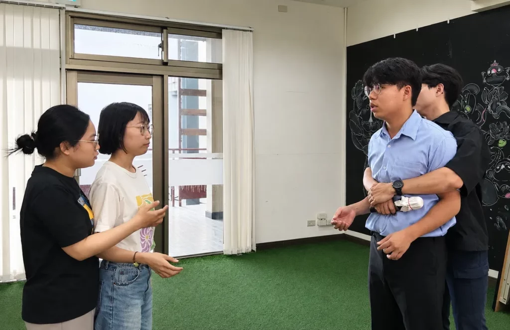 臺南市政府社會局人身安全講師王秋閔與助教鄧進賢與學員實際演練防身技巧。