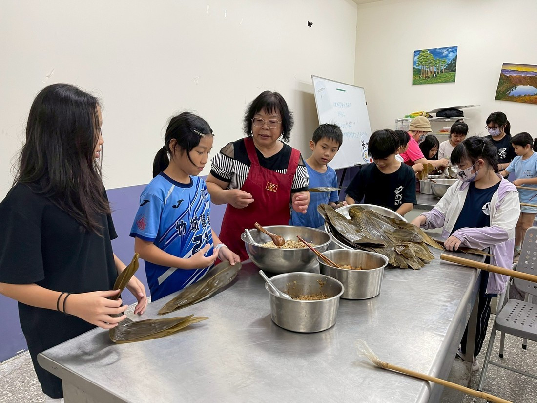水里國小學生於與家政志工媽媽們一同體驗包粽子，感受傳統節日的溫馨與意義。