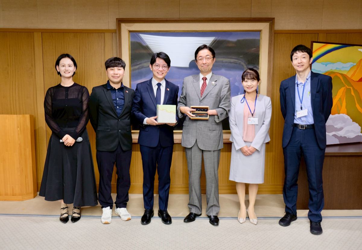 ▲高雄市青年局長林楷軒(左三)率團拜會日本熊本縣知事木村敬(右三),致贈高雄青創基地業者「大雄的木作世界」客製化手工木屐筆,熊本則以當地特製伴手禮回贈致意。