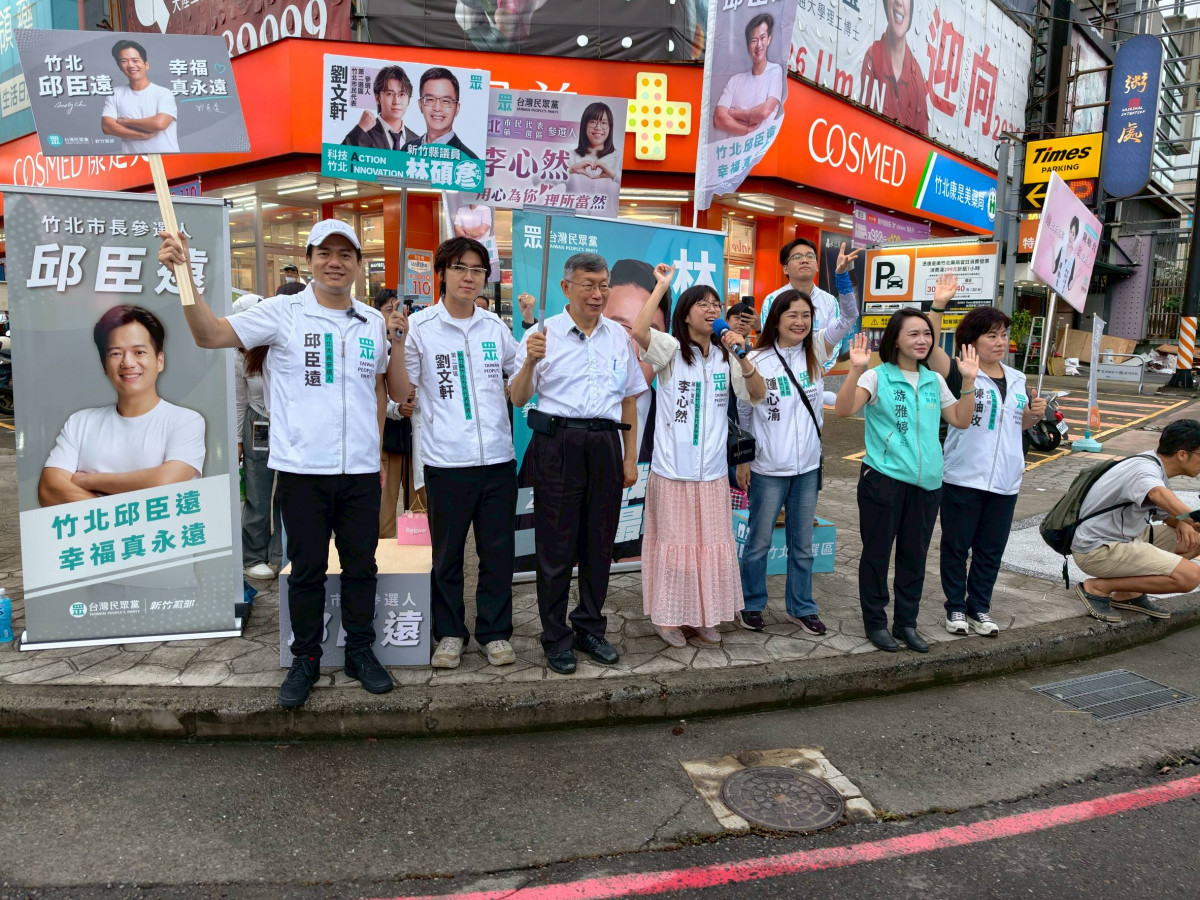 柯文哲與竹北市長候選人邱臣遠一行現身路口,吸引市民與過往車輛的目光。