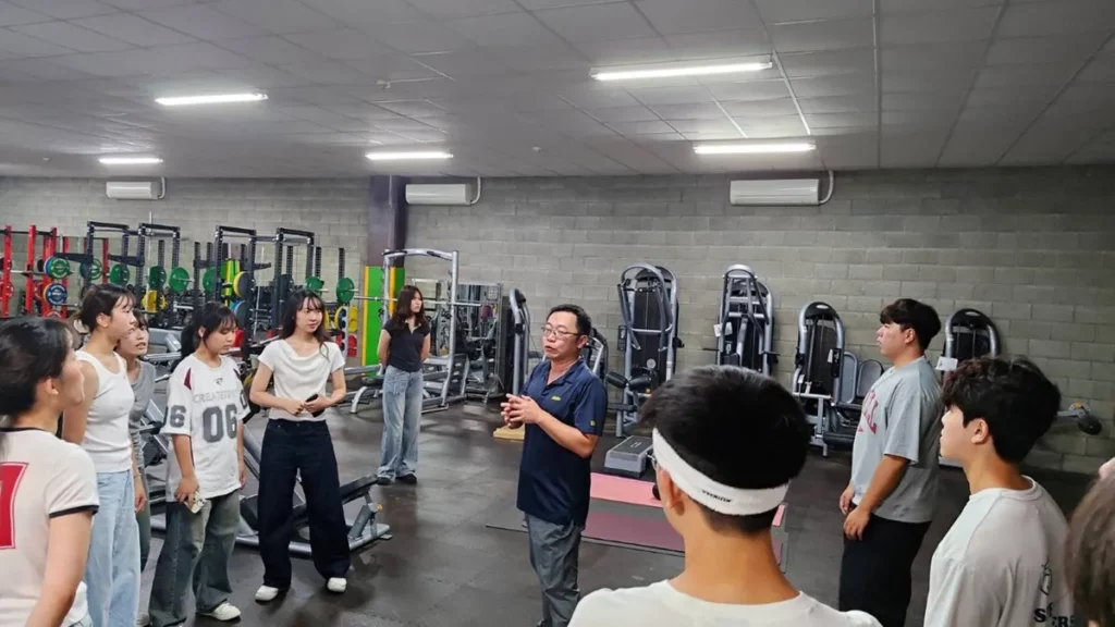 張誠崇帶領學生參觀球隊重量訓練室，介紹職業運動員體能培訓與表現提升策略。（圖/中山醫大提供）