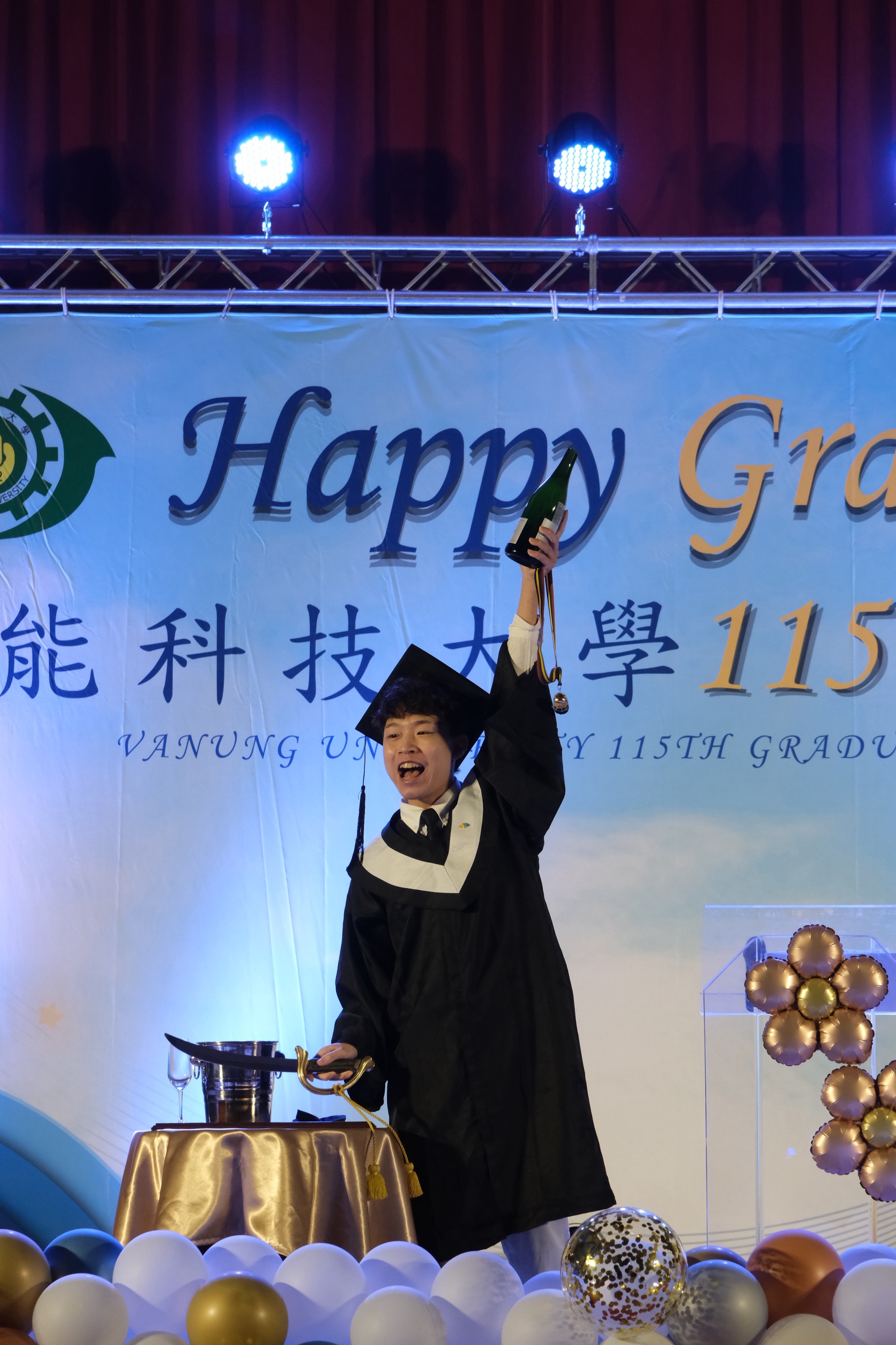 萬能科大畢典登場 莊暢:解決問題的能力不會被AI取代 圖四 萬能科大旅館系官柏均代表畢業生在台上進行香檳啟封儀式,並慶祝畢業。圖片:
