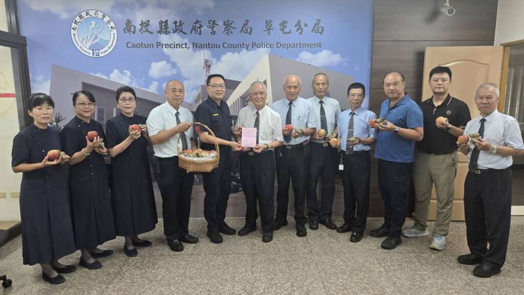 ▲志工們到草屯警察分局致贈蘋果及愛心粽由張基銘分局長(中)代表接受。
