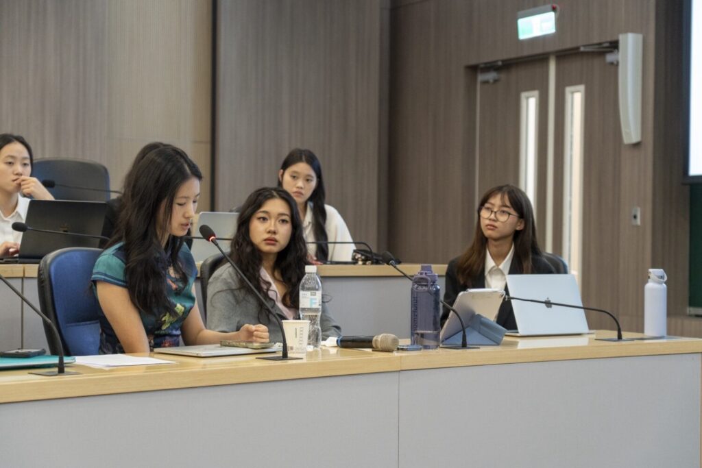 臺北市VIS國際實驗教育高中部 Honors Program 於政大公企中心舉辦Mini-Conference,20位學生聯合發表研究成果。左前至右,依序為學生許淳曦、張瑋倢、Yuriko 田中優利子。(圖/台北市VIS國際實驗高中提供)