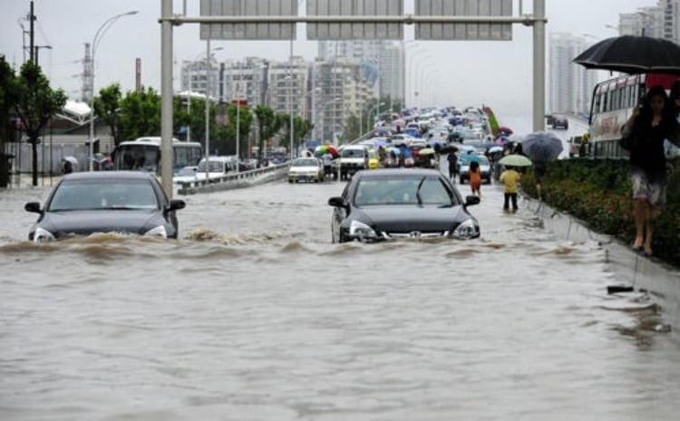 ▲端午首日武漢普降特大暴雨，城市道路大面積積水，車輛涉水難行，市民徒步蹚水出行。