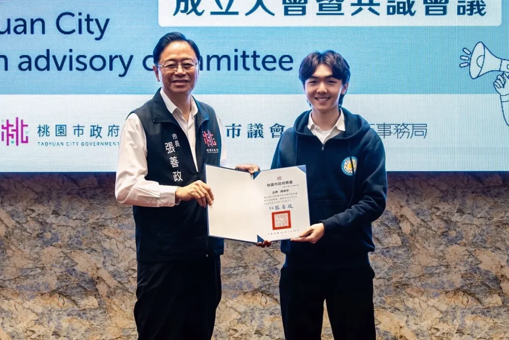 桃園市長張善政（左）頒發桃園市政府第7屆青年諮詢委員聘書予中山醫大醫管系學生鍾靖亭。（圖/中山醫大提供）