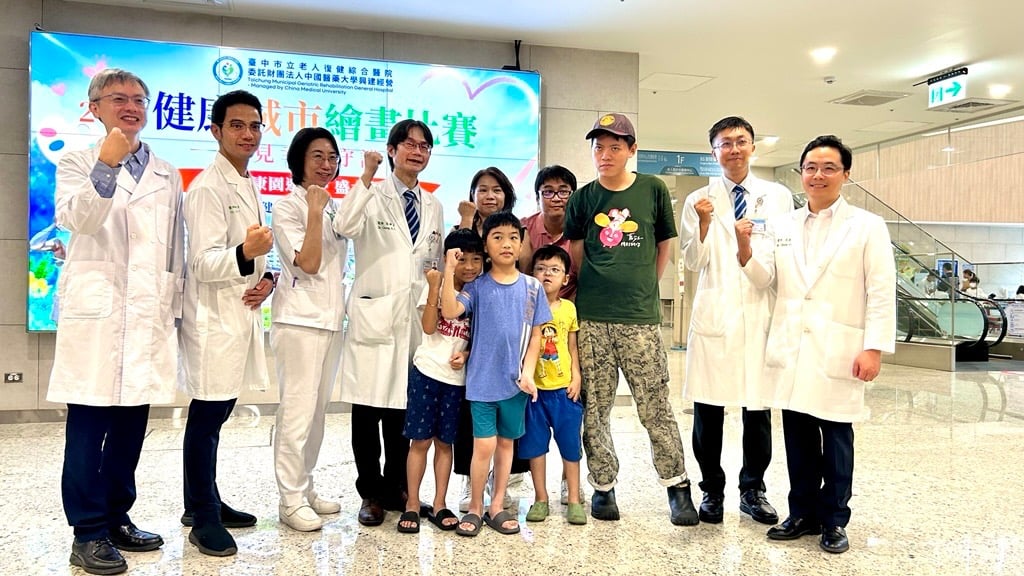 ▲中醫大市醫院長張坤正(左四)與罕見疾病基金會中部辦事處主任陳虹惠 (右五)邀請罕病家庭參與健康城市繪畫比賽。