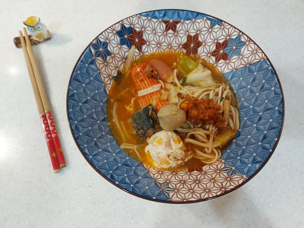 經典的「颱風麵」是許多台灣人的共同回憶,將麵條、雞蛋、青菜與各式食材下鍋,最後挖上一匙廣達香肉醬提味即可上桌。圖/鄭欣宜拍攝