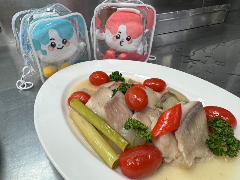 世界美食進校園 新北校廚研發異國料理豐富午餐 34 《圖說》「拿坡里水煮魚」融合義式拿坡里風味與健康烹調理念,以番茄、香草及多樣蔬菜襯托魚肉鮮甜,呈現兼具營養、美味與國際特色的創新校園料理。〈教育局提供〉