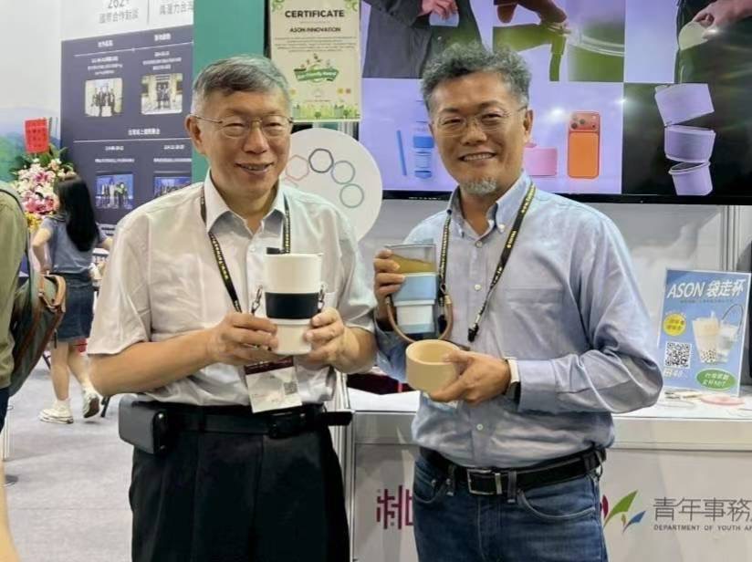 前台北市長柯文哲(左)於COMPUTEX展覽期間參觀ASON袋走杯展位,與ASON袋走杯發明人梁仁宇(右)合影,並體驗產品創新設計。(圖/業者提供)