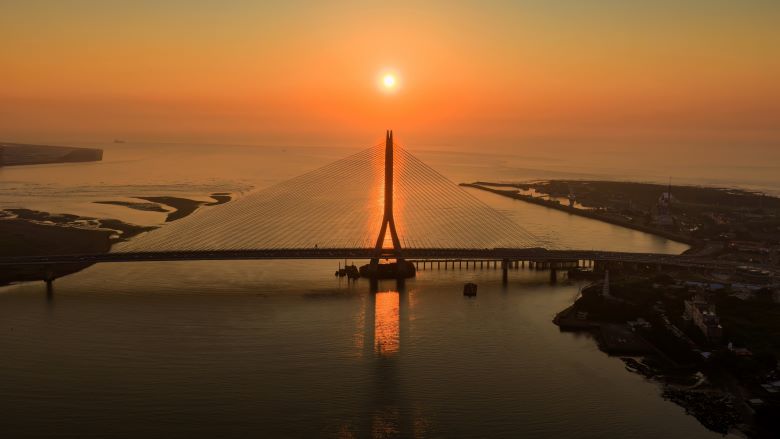 台北夏季旅展7/17登場 新北館6業者推優惠手作DIY吸客 35 《圖說》淡水河口的金黃夕照與宏偉的淡江大橋巧妙相遇,橋塔的俐落剪影與波光 粼粼的水面勾勒出專屬淡八地區的嶄新觀光地標。〈觀旅局提供〉