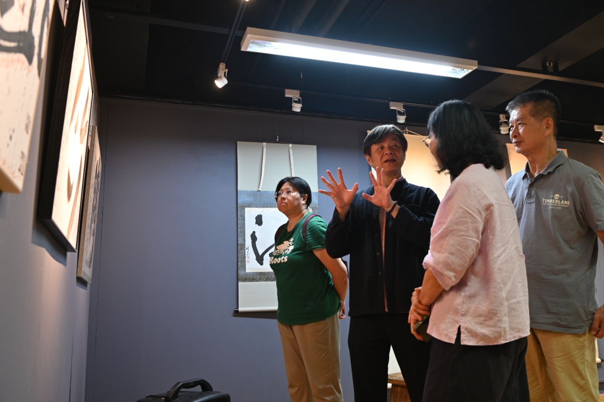 圖/策展人華梵大學人文與藝術學院黃智陽院長(左二)向參觀者導覽作品