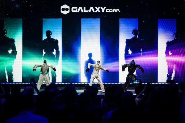 Three humanoid robots perform a K-POP choreography on stage during the finale of the UN 'AI for Good' Summit, with the Galaxy Corp. logo displayed prominently in the background