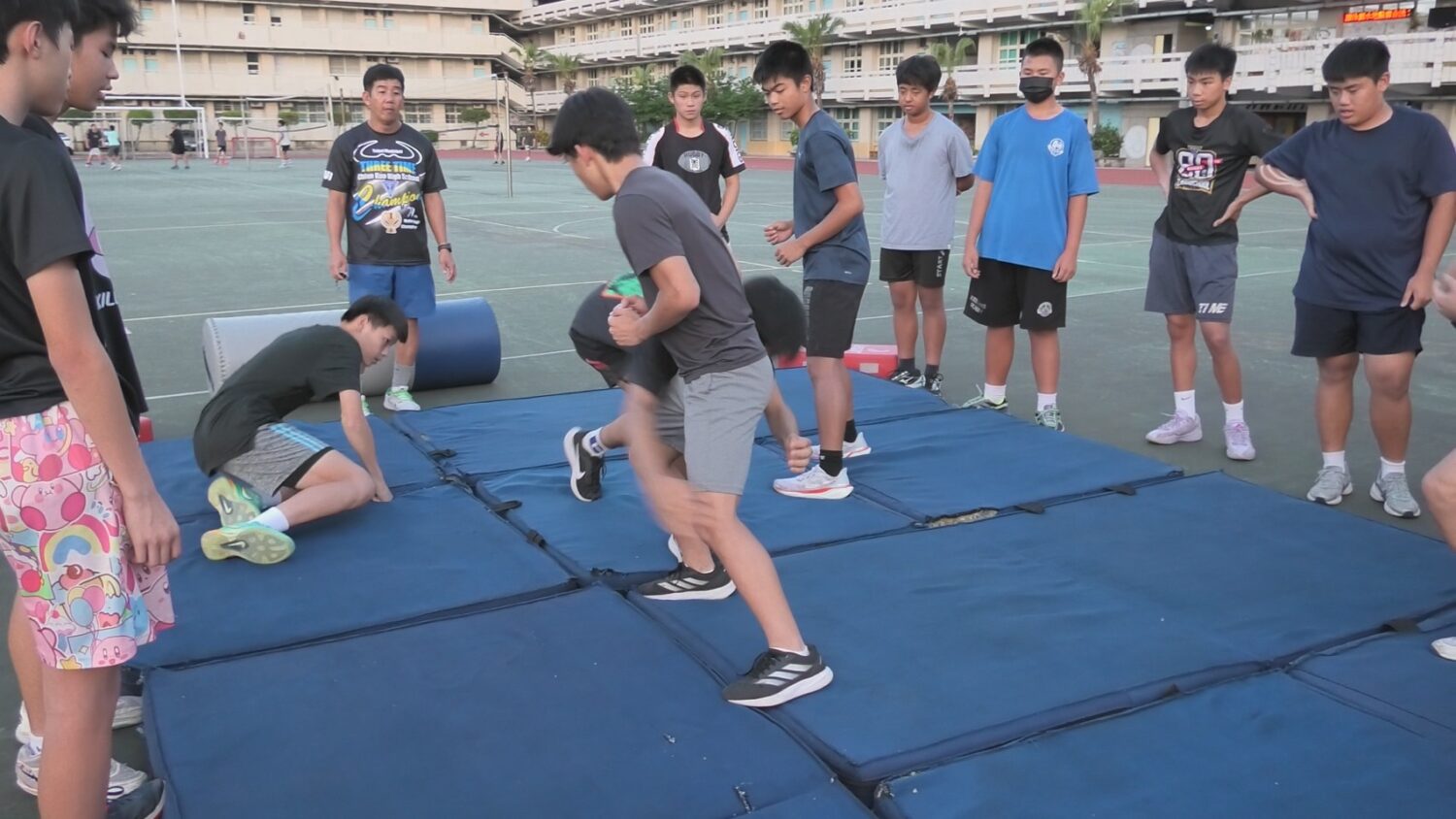 明志國中於水泥地操場鋪設軟墊，供球員練習撲倒動作。（圖／天合國際娛樂提供）