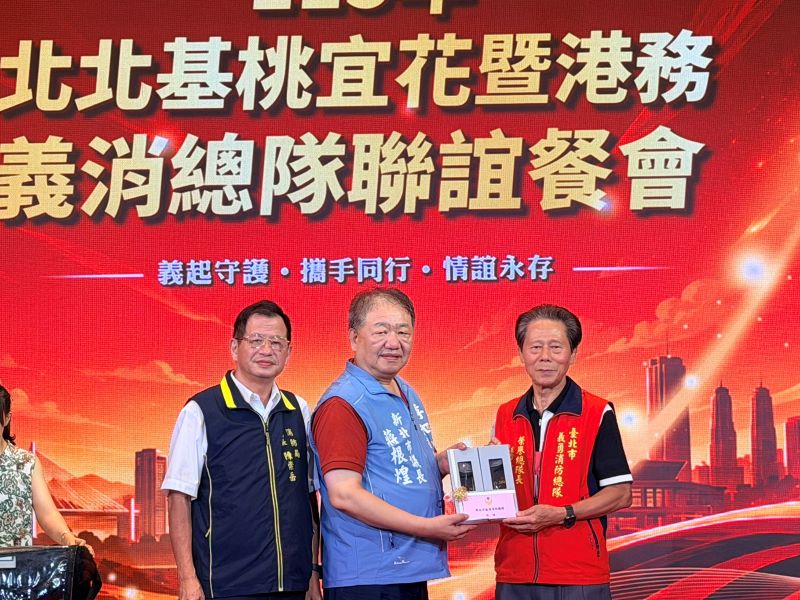 分享救災經驗攜手提升應變量能 北北基桃宜花暨港務義消齊聚新北 23 《圖說》新北市議長、新北市義消總隊長蔣根煌致贈交流紀念,左一新北市消防局長陳崇岳。〈消防局提供〉