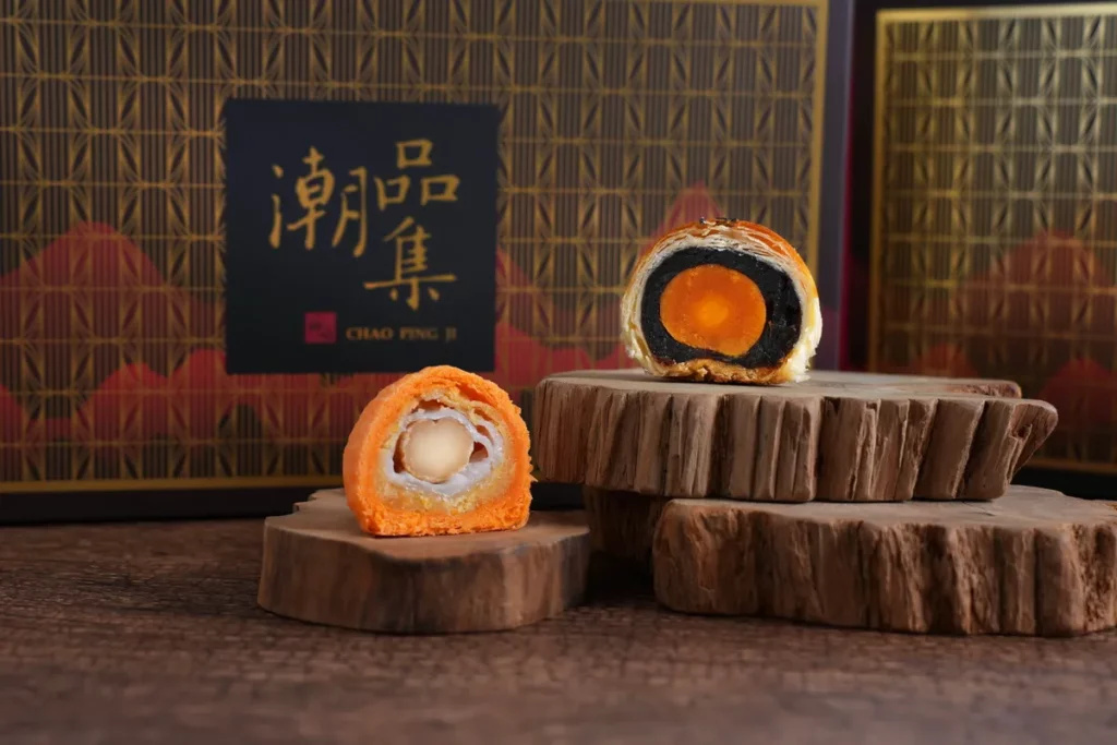 潮品集「潮香雙月禮盒」的雙倍雪Ｑ月皇酥選用低糖綠豆餡調合白蓮蓉，並包入麻糬皮增加Ｑ度咀嚼感，再加入需經燙、炸、烘烤三道工序處理的夏威夷豆，堪稱「含金量很高」的月餅。  (圖/潮品集提供)