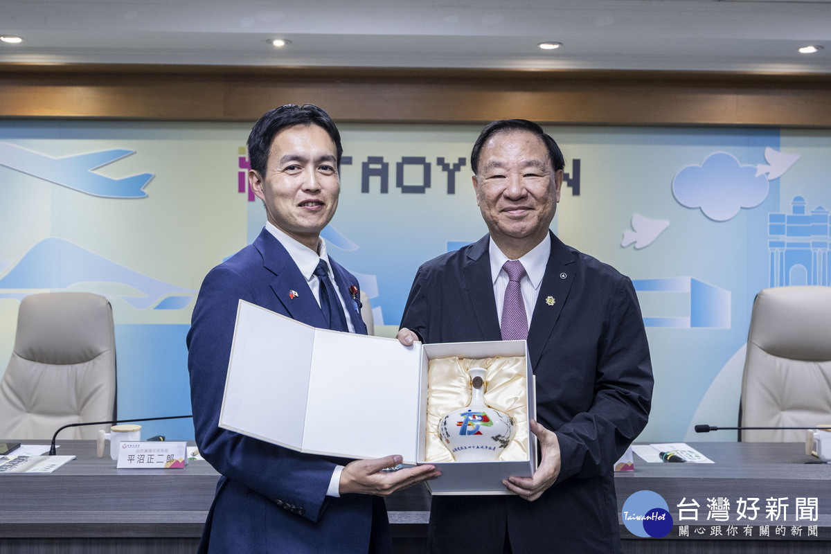 中國青年救國團主任葛永光與自民黨青年局長平沼正二郎交換紀念品。