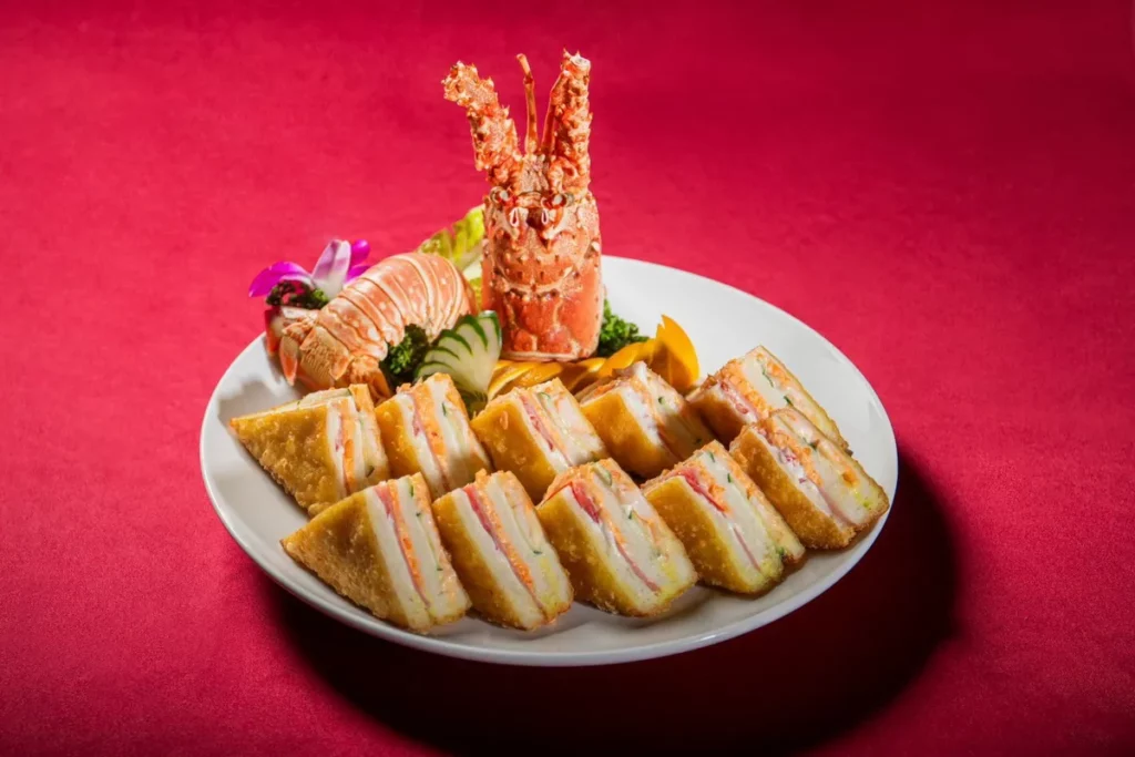 台北凱達大飯店「呷辦桌」經典臺菜宴中的「龍蝦三明治」,以酥脆吐司包裹鮮美龍蝦餡