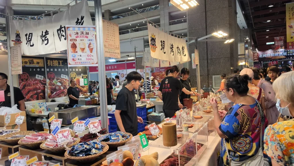 伴手禮展區香氣四溢，各大攤位紛紛祭出排隊美食，展示多款特色伴手禮與限定禮盒，現場買氣熱絡。（上聯國際展覽提供）