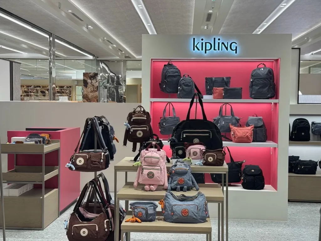 Kipling 全新SOGO大巨蛋新櫃採開放式設計，中央展示桌搭配周圍層架及壁面陳列，不同系列包款整齊排開，讓各式包型一目了然